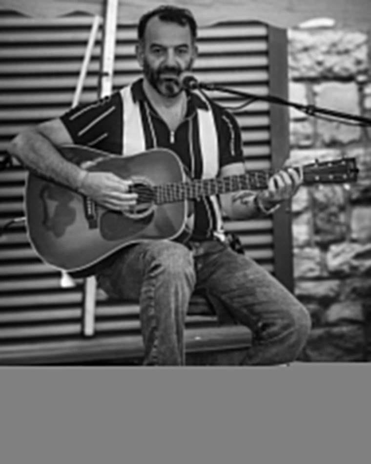 Portrait noir et blanc d’un guitariste assis