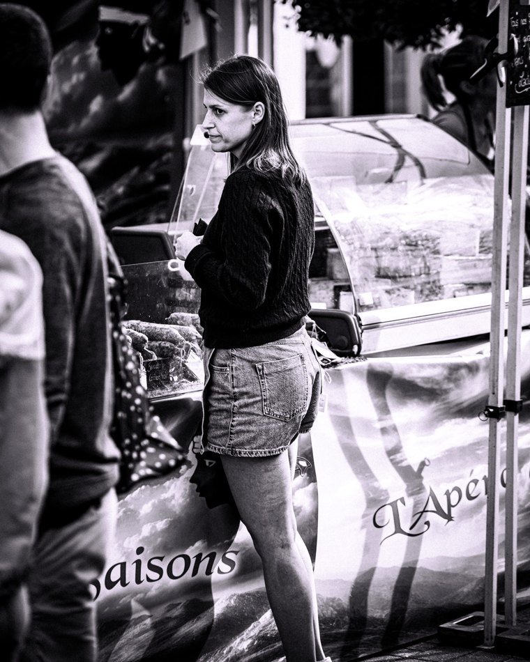 Jeune femme appuyée près d’une voiture dans la rue